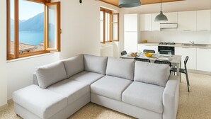 Een modern interieur met een modulaire bank, een eettafel, stoelen en een keukenhoek.
