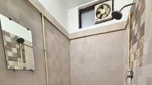 A bathroom with a white sink, a mirror, a handheld showerhead, a small window with a fan, and a white bucket. - Beautiful 1-bedroom hotel with AC in peaceful Rishikesh (Rishikesh)