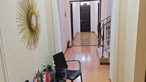 A hallway with a seating area, a decorative wall piece, and a staircase. - Tashkent Atlas  (Tashkent)