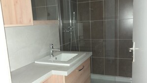 A bathroom with a wooden vanity, a sink, a mirror, and a shower enclosure. - T2 APARTMENT ON 1ST FLOOR 200 M FROM GRANDE PLAGE AND SHOPS (Saint-Cast-le-Guildo)