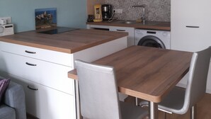A modern kitchen with a wooden island, white cabinets, a coffee maker, and a washing machine. - T2 APARTMENT ON 1ST FLOOR 200 M FROM GRANDE PLAGE AND SHOPS (Saint-Cast-le-Guildo)