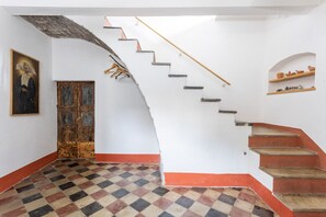 Eine Treppe mit einem Holzgeländer, einem Schachbrettfußboden und einer Tür mit Holzrahmen.