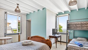 Une chambre avec un lit, un bureau, un ordinateur et un lit superposé.