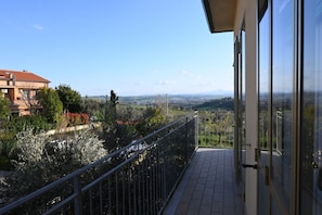 A balcony with a metal railing, a tiled floor, and a view of a distant landscape. - SE235 - Senigallia, large three-room apartment with furnished courtyard (Roncitelli)