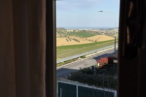 A view from a window overlooking a road with fields and a distant town. - SE235 - Senigallia, large three-room apartment with furnished courtyard (Roncitelli)