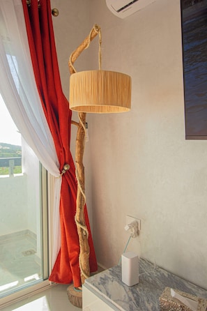 A room with a window, a lamp with a unique design, a marble countertop, and a tissue box.