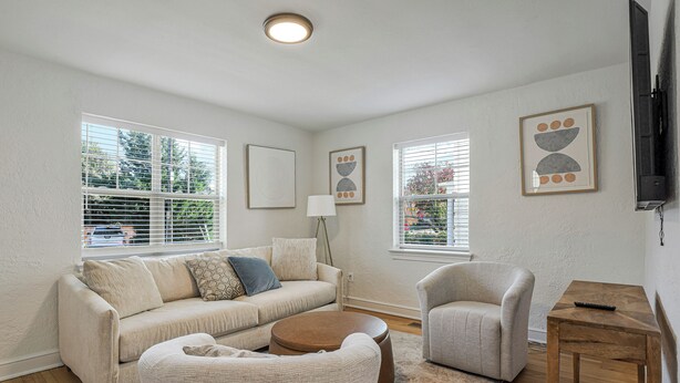 A living room with a sofa, armchair, coffee table, and a TV stand. - Cozy 1BR1BTH in Old Town Alexandria -Steps From Metro (Alexandria)