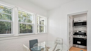 A compact kitchen with white cabinetry, a microwave, and a stove. - Cozy 1BR1BTH in Old Town Alexandria -Steps From Metro (Alexandria)