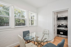 A compact kitchen with white cabinetry, a microwave, and a stove.