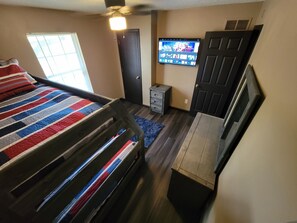 A bedroom with a bed, a desk, a television, and a wardrobe. - 3-bedroom townhome in adorable Kansas City with AC (Kansas City)