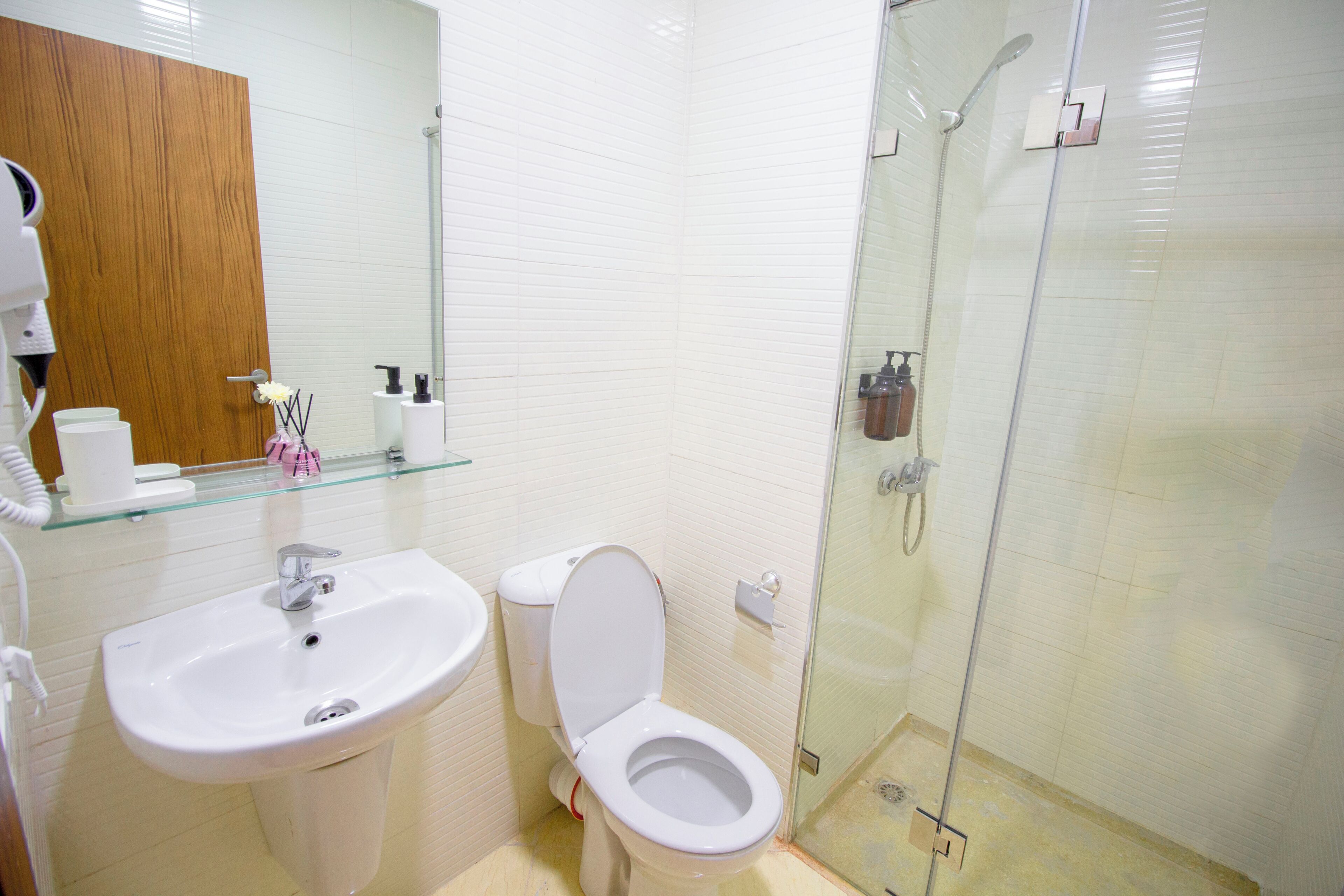 A bathroom with a white sink, toilet, and glass shower enclosure.