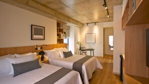 A hotel room with two beds, a desk, and a chair. - Kubik Living 8i8 (Bogota)