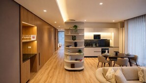 A modern living room with a round coffee table, a sofa, and a built-in bookshelf. - Kubik Living 8i8 (Bogota)