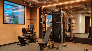 A gym with exercise equipment, a mirror, and a large window.
