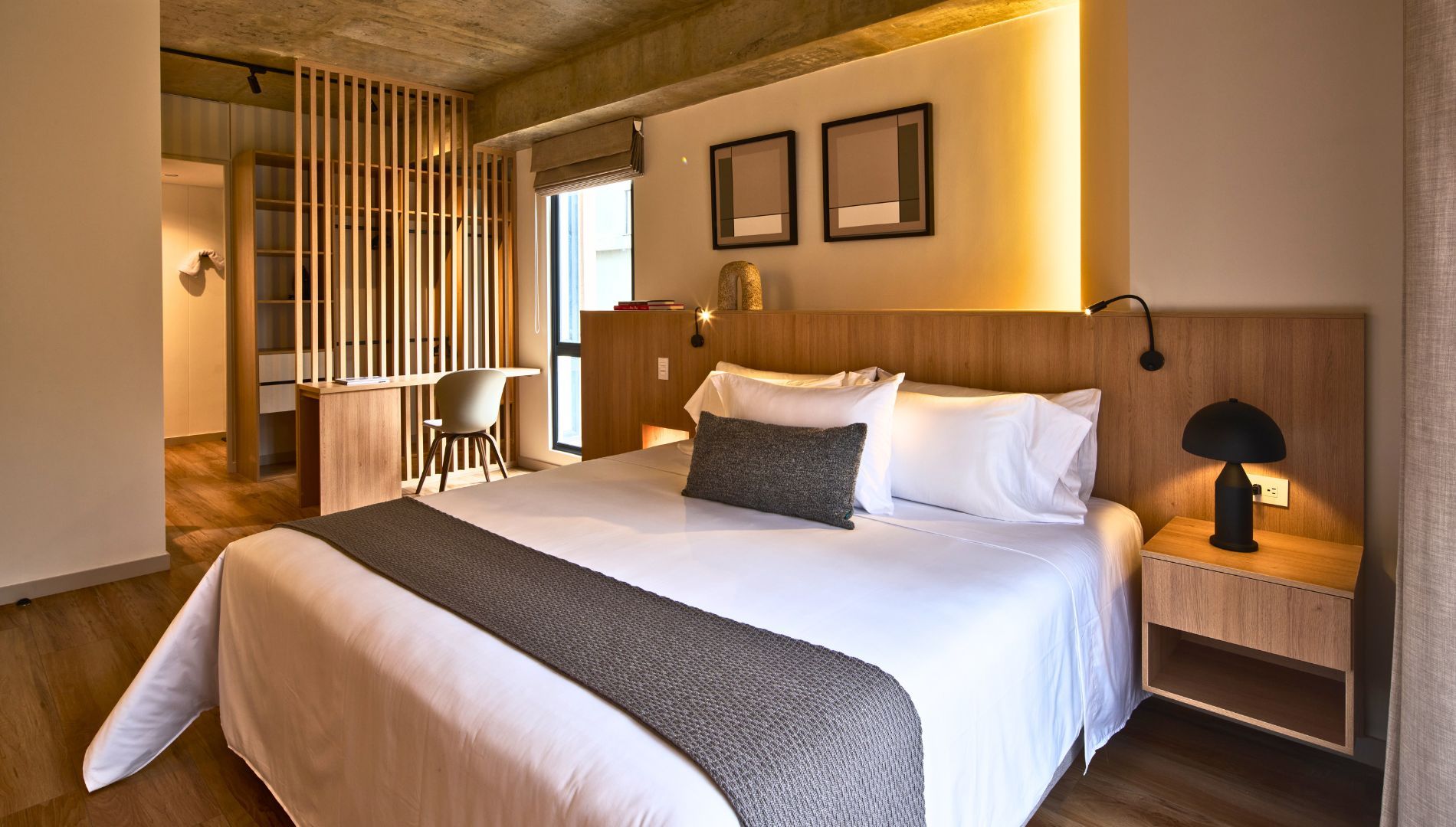 Una habitación de hotel moderna con una cama grande, un escritorio y una silla.