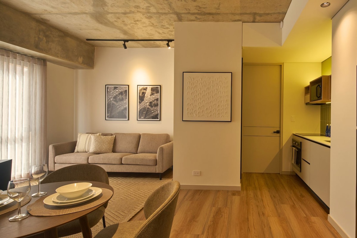 A compact living space with a sofa, dining table, and kitchen area.