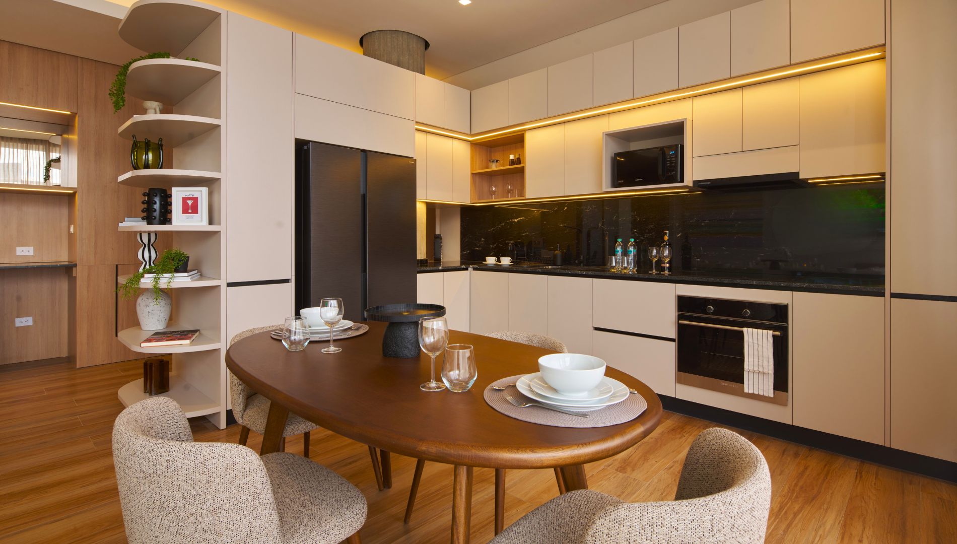Una cocina moderna con comedor, que incluye una mesa redonda de madera, sillas y electrodomésticos empotrados.