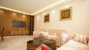 A modern living room with a sofa, armchairs, a coffee table, and decorative wall art. - Luxury 2-Bedroom Pool, Quiet & Spacious (Tanger)