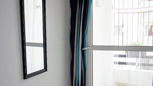 Een kamer met een schuifdeur van glas, een lijstkast en een betegelde vloer.