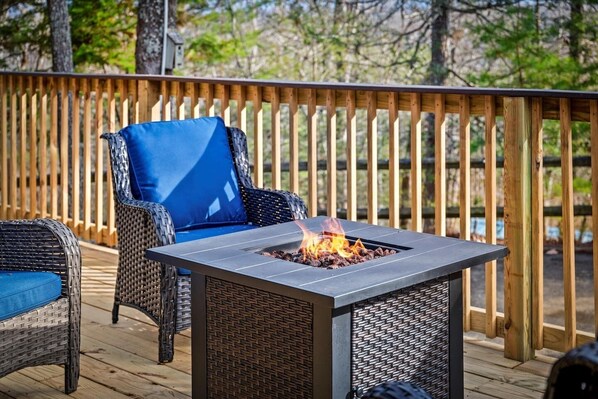 A deck with a metal fire pit and wicker furniture. - Cabin w/ 2 Hot Tubs · Theater · Game Room (Sevierville)