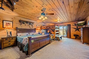 Un dormitorio acogedor con una cama de madera, un ventilador de techo y un ventanal grande.