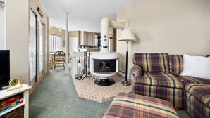Una sala de estar acogedora con chimenea, televisor y sofá.