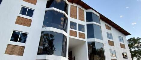 A multi-story building with large windows and a flat roof.