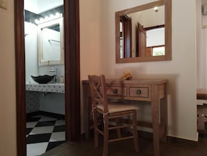 A bathroom with a sink, mirror, and wooden desk with drawers. - Mistral Patmos (Patmos)