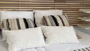 A bed with a wooden headboard, white pillows, and a white bedspread. - La Lézardière House with swimming pool in Ruoms, close to nature and rivers (Ruoms)