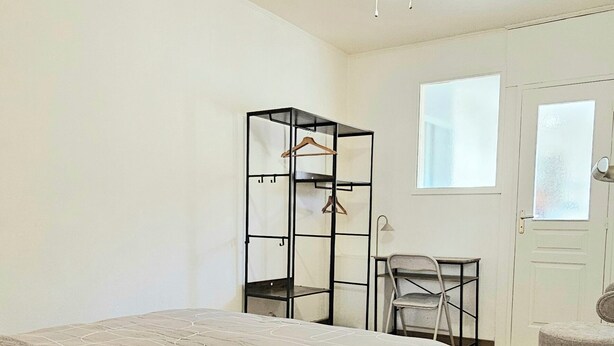 A bedroom with a bed, a wardrobe, a chair, a desk, and a ceiling fan. - Cosy T2 in downtown Le Mans, 15 minutes from the 24h circuit (Le Mans)