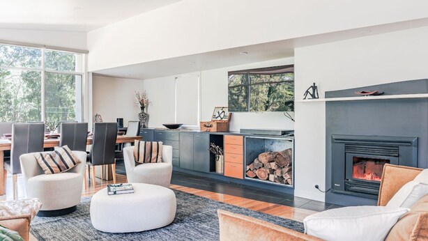Una sala de estar moderna con chimenea, un comedor y una cocina.