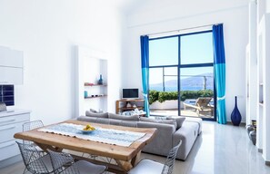 A modern living room with a sofa, a wooden dining table, and a TV. - The White Collection - Villa Sky (Kaş/Antalya)