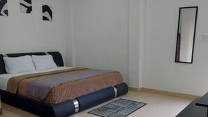 Ein Schlafzimmer mit einem Bett, einem Spiegel und einem gemusterten Teppich.