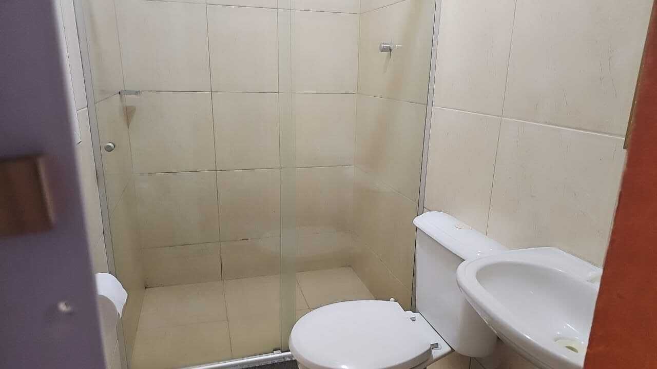A bathroom with a shower, toilet, and sink.