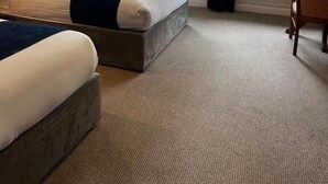 A hotel room with two beds, a small table, and a window with a view of trees. - Fernhill Lodge Carrigaline (Carrigaline)