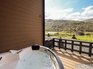 A hot tub on a wooden deck with a view of a rural landscape. - Bluebelle - Crossgate Luxury Glamping (Penrith)