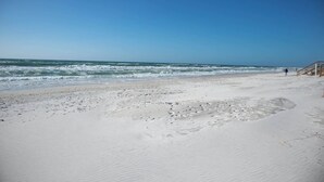 A beach with a wooden walkway leading to the water, sandy beach, and waves. - Rehab- Beach front, Sleeps 9 (Port St. Joe)