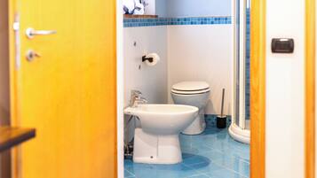 Ein Badezimmer mit Toilette, Bidet und Duschbereich.