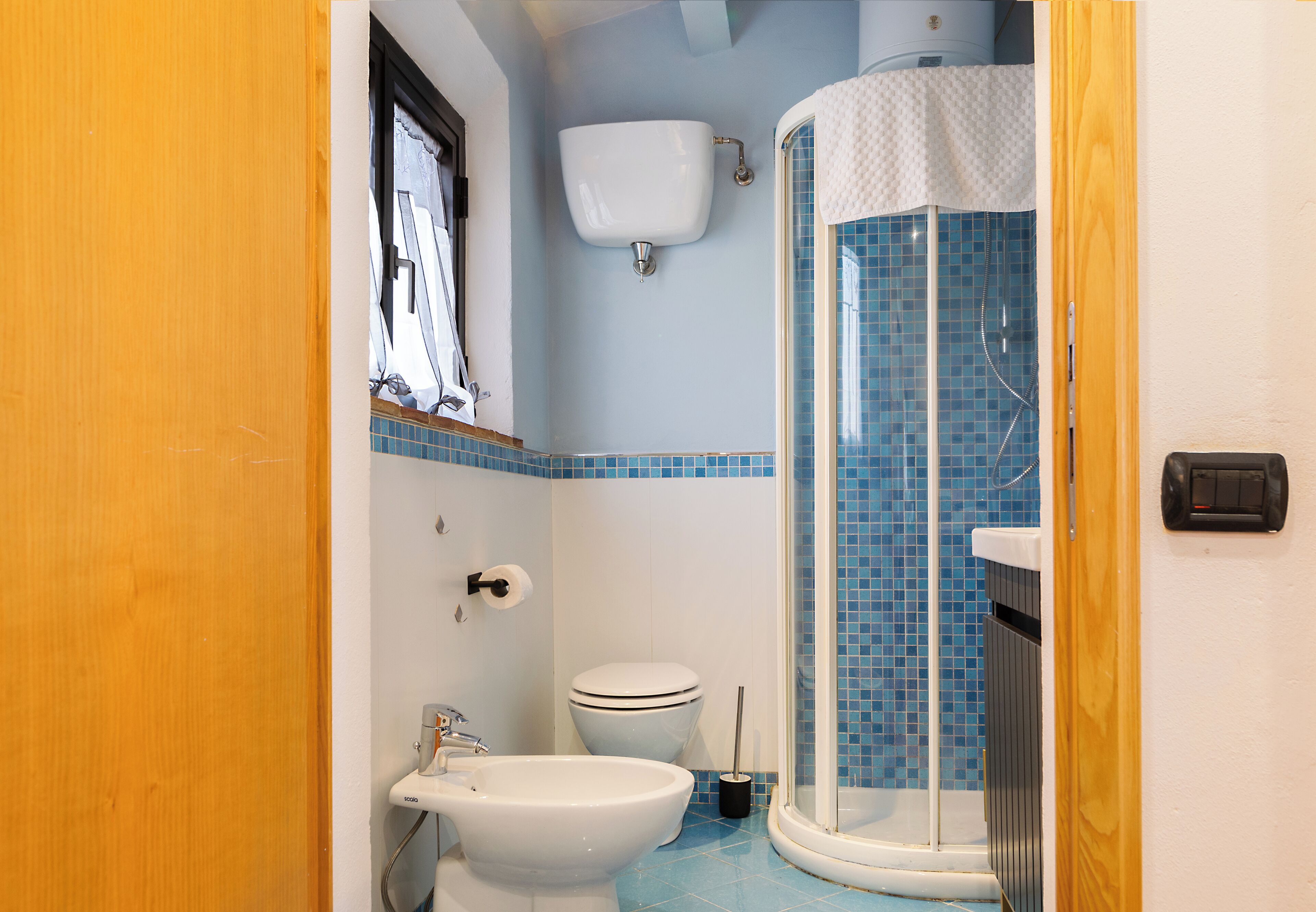 Een badkamer met een douche, toilet en wastafel.