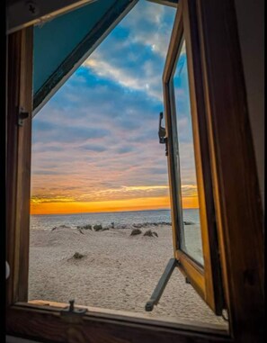 Een uitzicht op een strand bij zonsondergang.