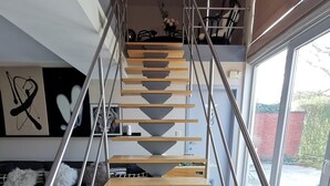 A modern staircase with a minimalist design, metal railings, and a view of the outdoors.