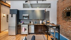 A modern kitchen with a built-in oven, a refrigerator, and a dining area with a table and chairs.