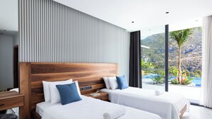 A modern hotel room with two beds, a wooden headboard, a large window with a view of a pool and mountains, and a nightstand with a lamp. - Villa Sade: A Modern Luxury Retreat with Infinity Pool and Sweeping Views (Kaş/Antalya)