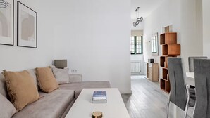 Una sala moderna con un sofá, una mesita de centro y una estantería.