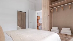 Un dormitorio con cama, un armario de madera y una puerta.