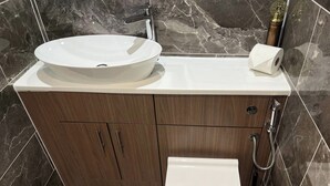 A bathroom with a white sink, wooden vanity, a toilet, and a shower. - Central 1 Bed Apartment - Sleeps 2 With Wifi (Wellingborough)