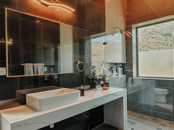 Een douche, handdoeken, zeep, toiletpapier