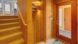 A wooden staircase leading to a room with a door and a window. - Modern Mountain Getaway at Loon (Lincoln)