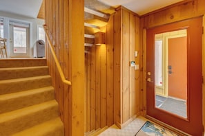 A wooden staircase leading to a room with a door and a window. - Modern Mountain Getaway at Loon (Lincoln)
