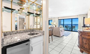 Eine moderne Küche mit Granit Arbeitsplatten, einem Geschirrspüler und einem Essbereich mit Balkon mit Blick auf das Meer.
